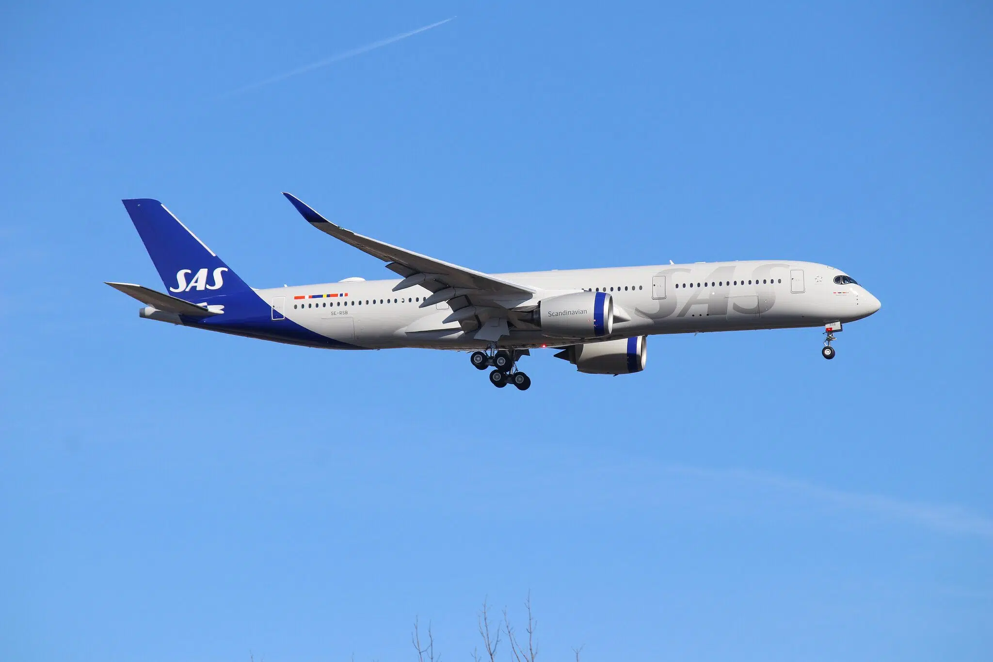 A large passenger jet flying through a blue sky