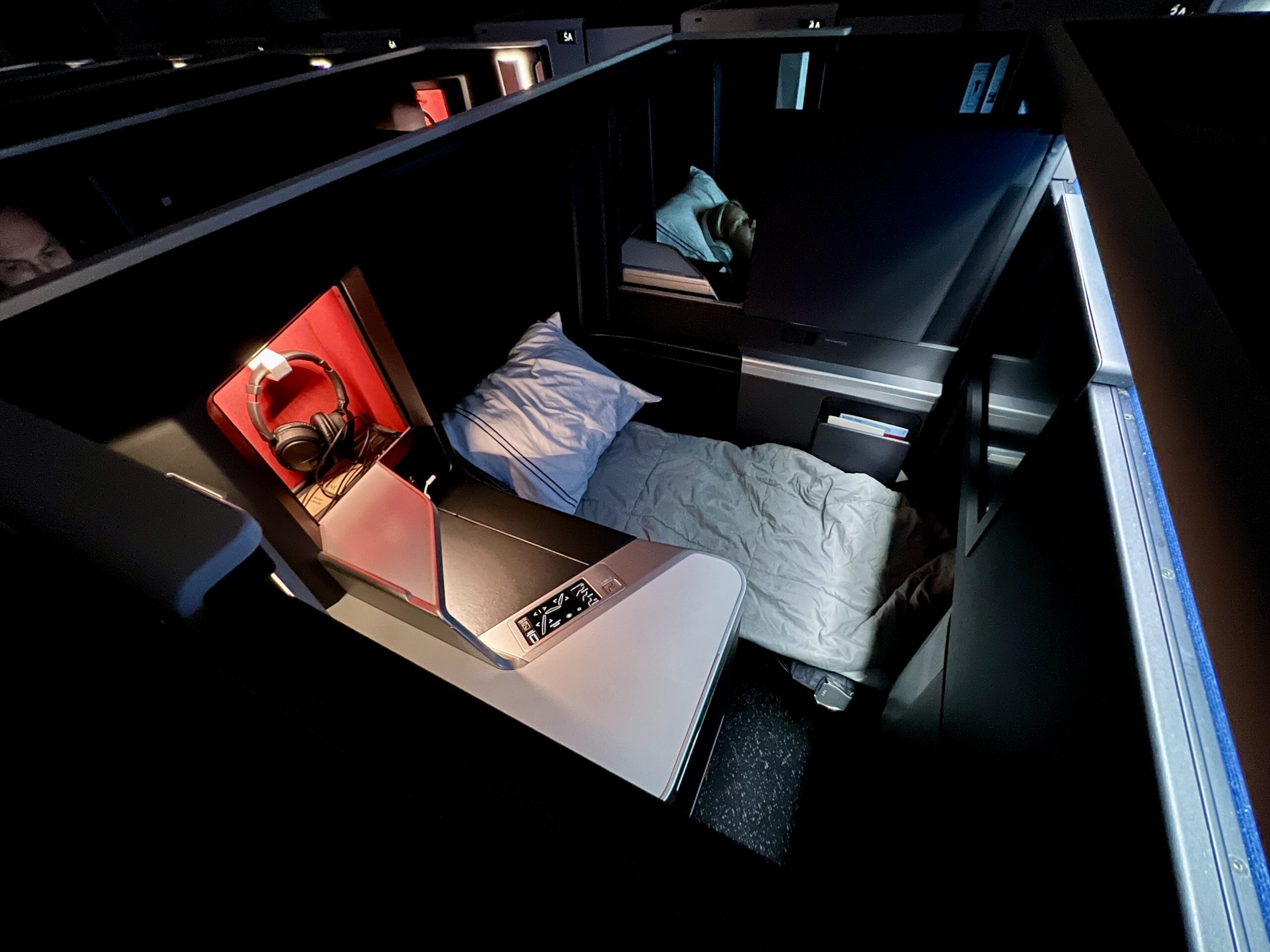 bed with pillow and blanket inside a business class suite