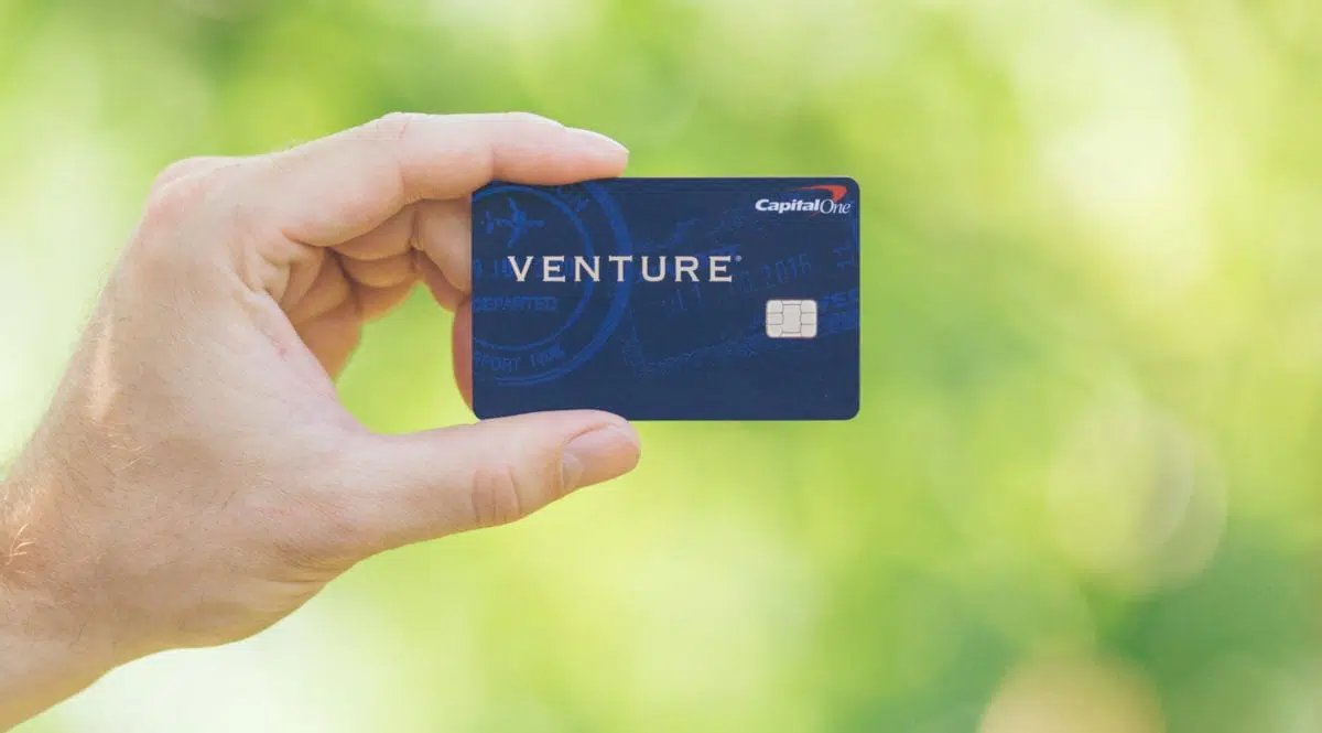 A man holding a Capital One Venture Rewards Card