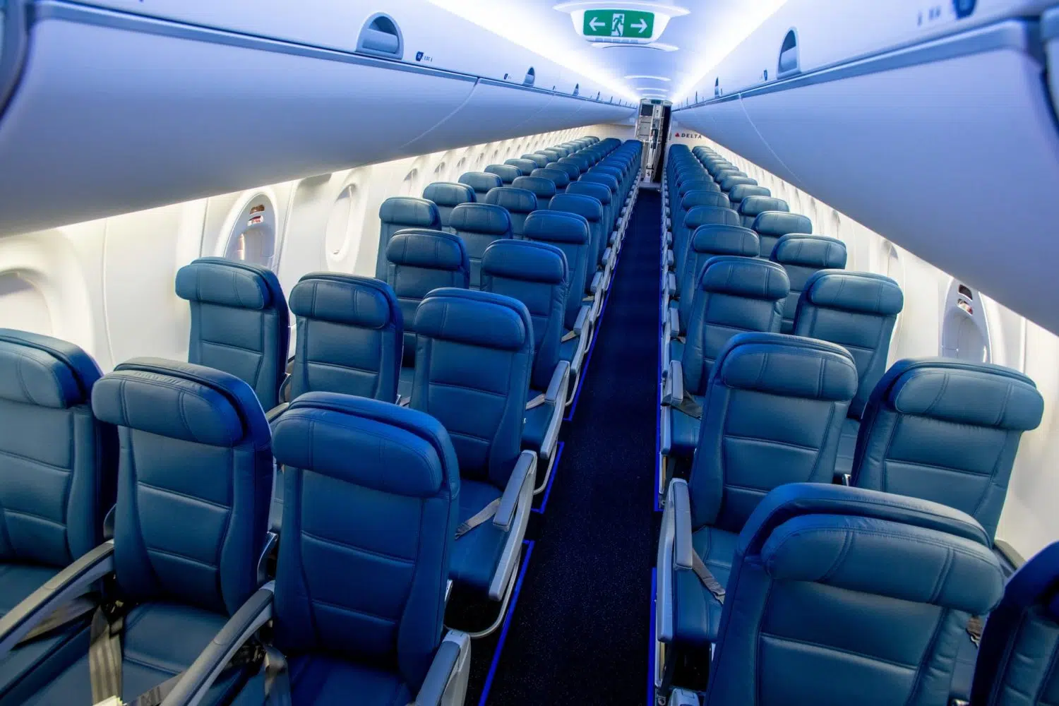 rows of blue leather seats on an airplane 