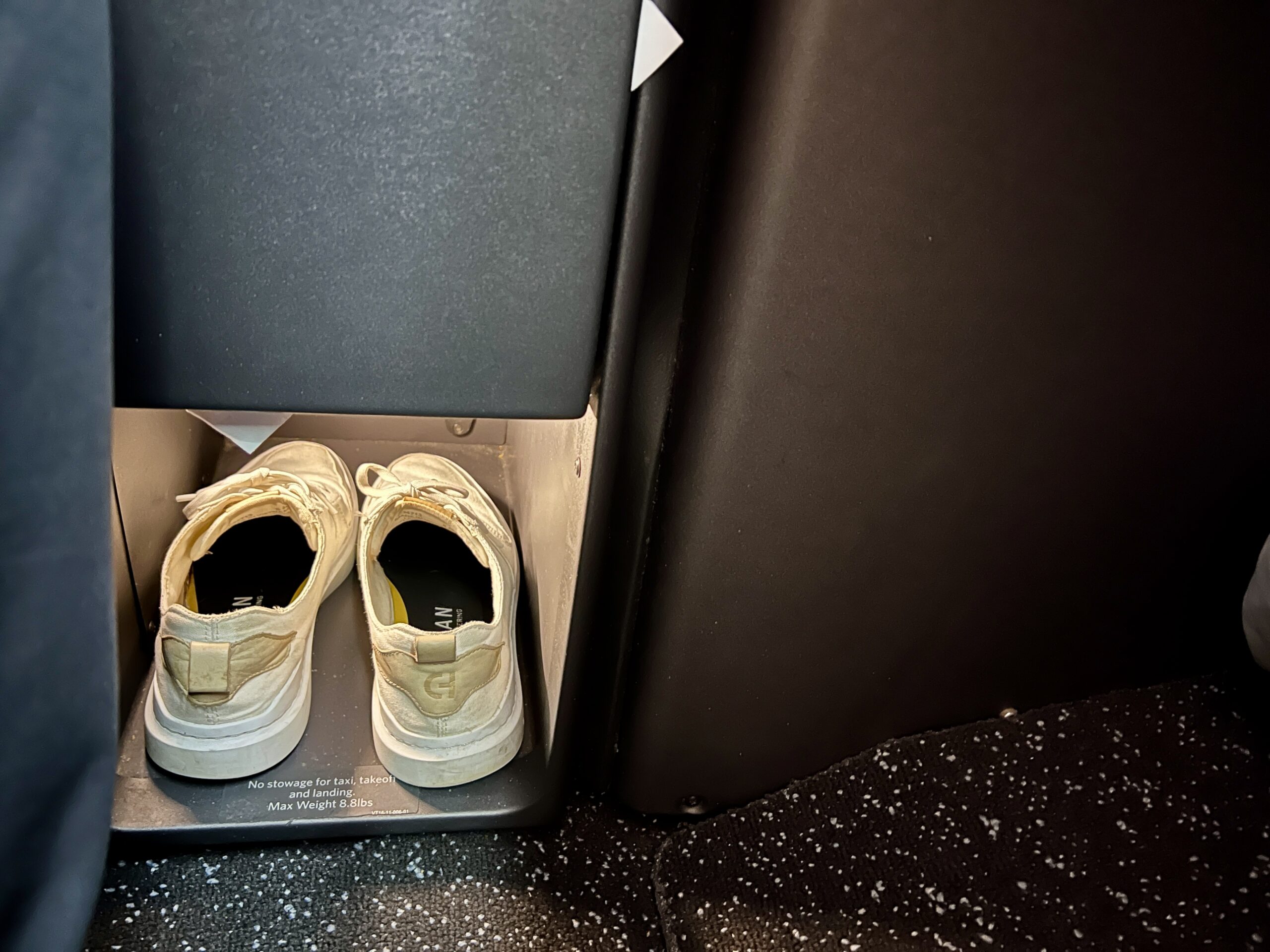 a pair of shoes inside of an airline business class seat