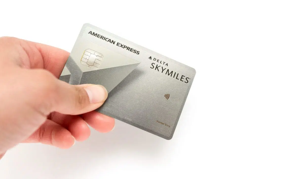 a person holding a Delta SkyMiles platinum American express card