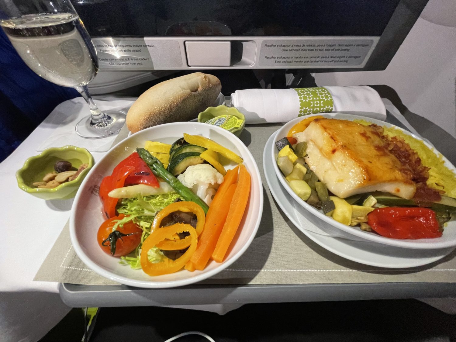 fish and a bowl of vegetables on a plane tray