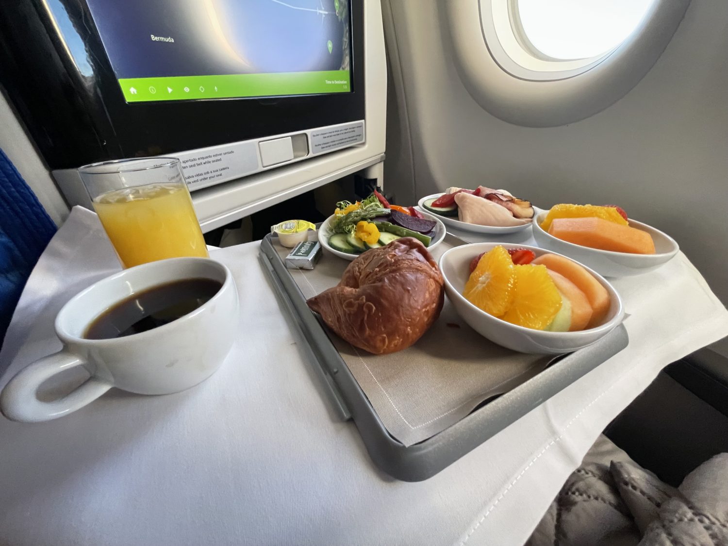 coffee and tray of baked good and fruit with cold cuts