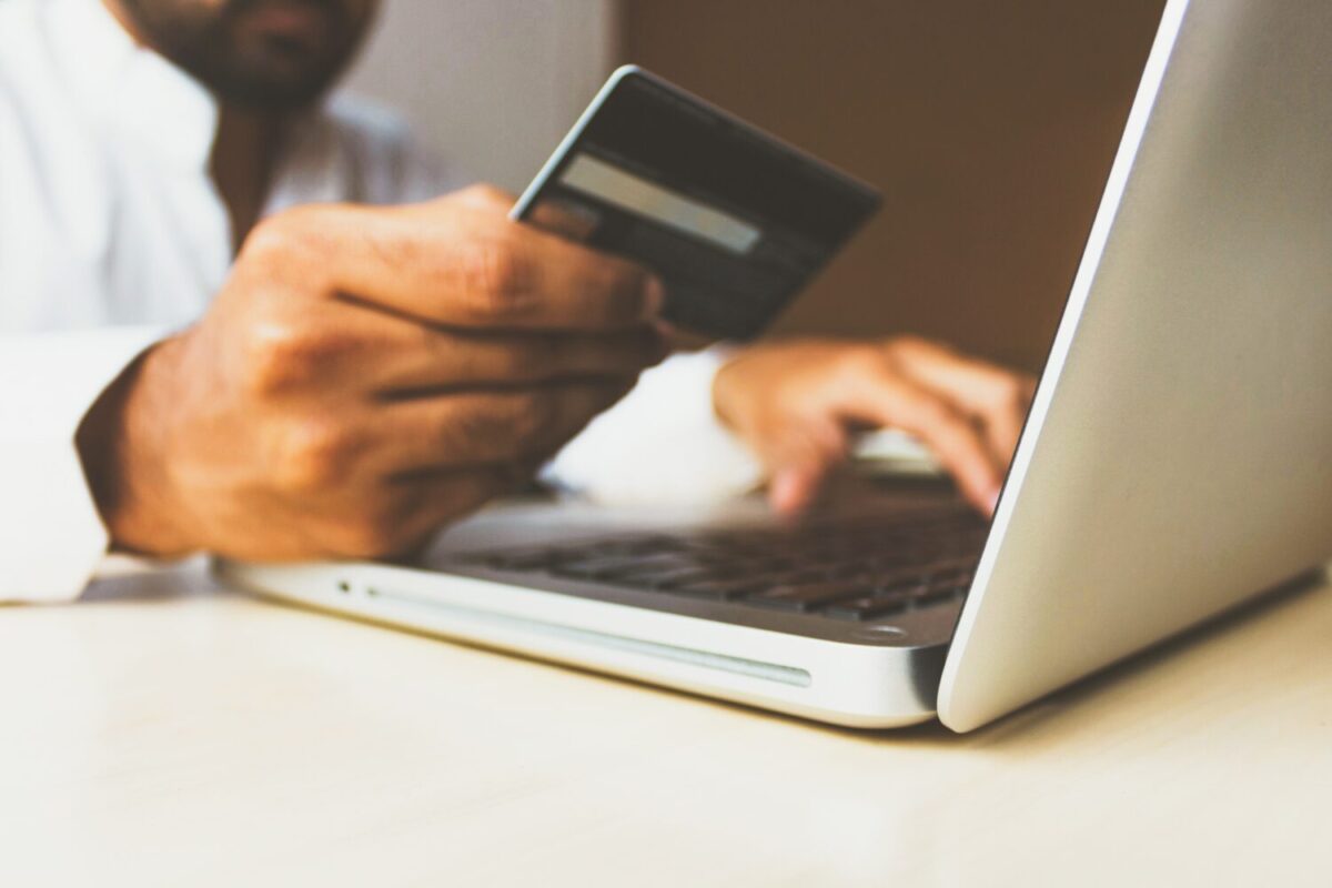 man holding credit card at computer